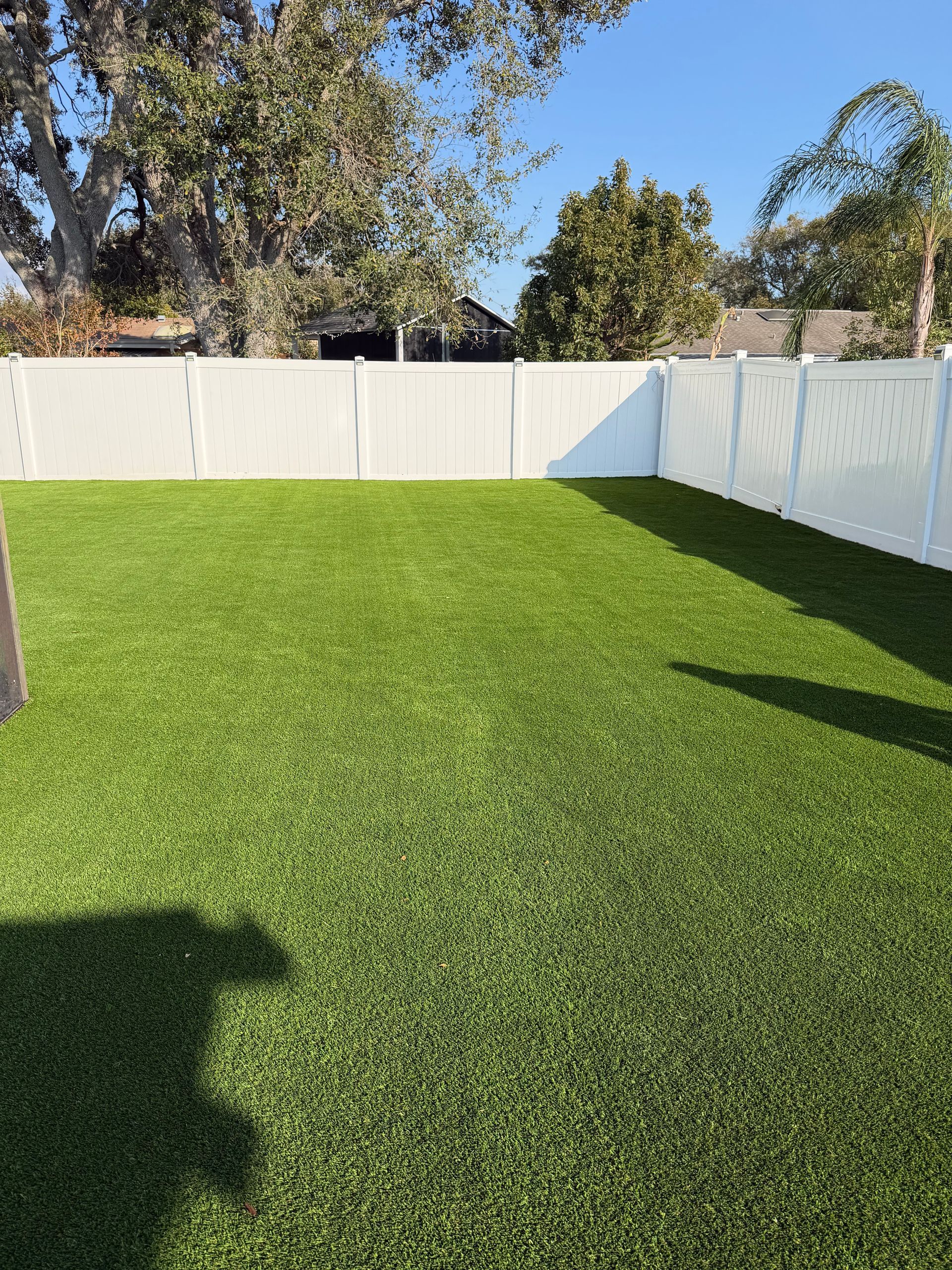 Roll of artificial turf unraveled on green surface.