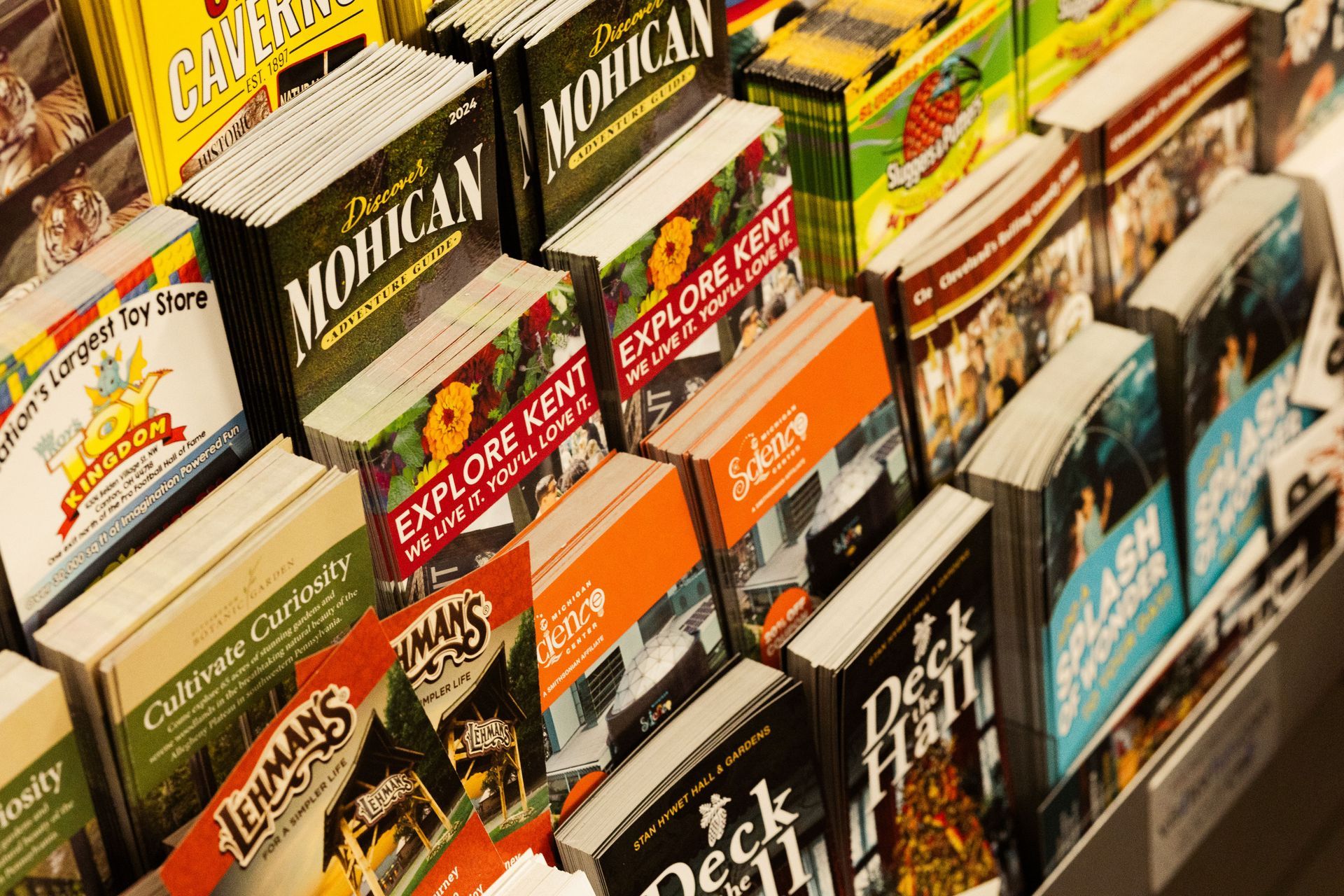 Rows of colorful magazines and newspapers stacked on a rack in a store aisle