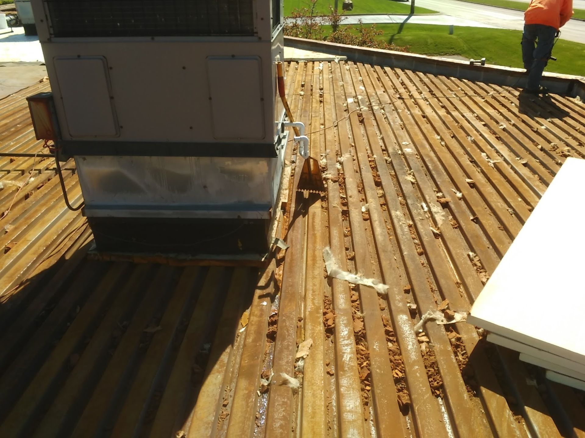 Roof with solar panel installation and a worker standing on a wooden deck