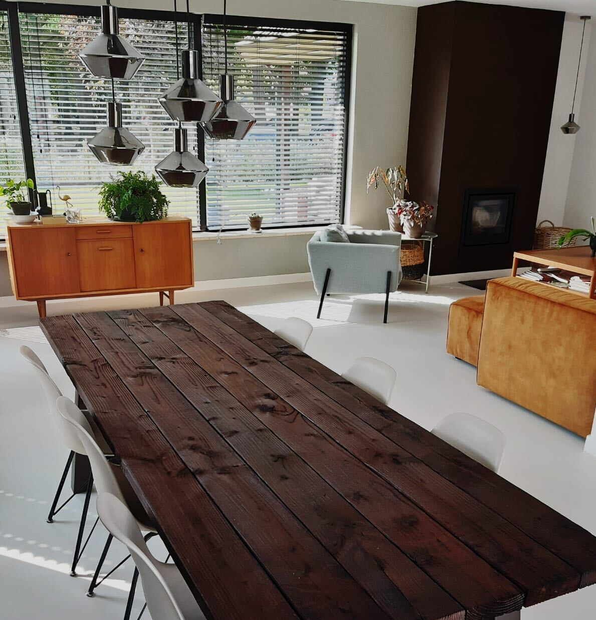 Een woonkamer met een houten tafel en stoelen