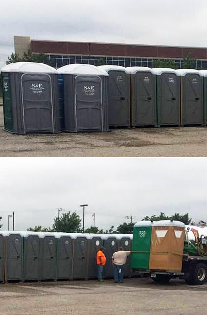 A row of portable toilets are lined up in a parking lot.