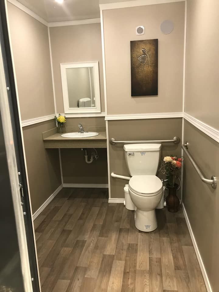 A bathroom with a toilet , sink and mirror.