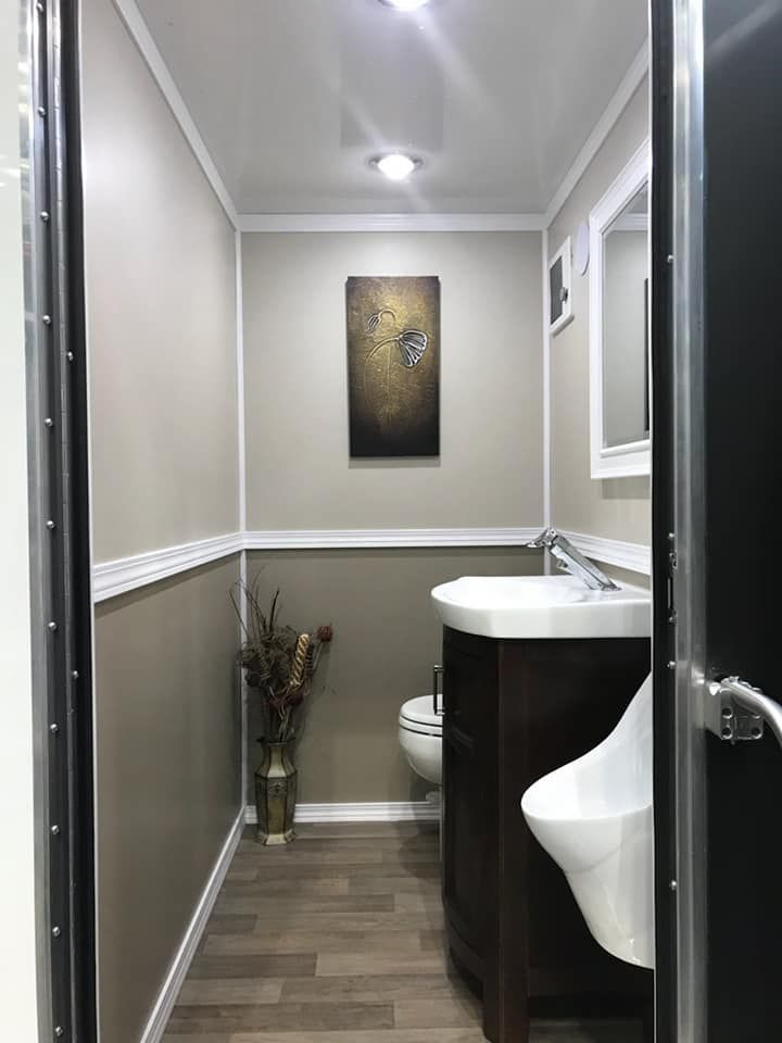 A bathroom with a sink , toilet and urinal.