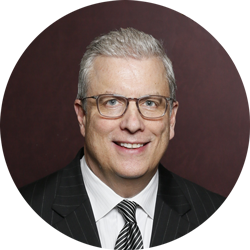 A man in a suit and tie is smiling in a circle