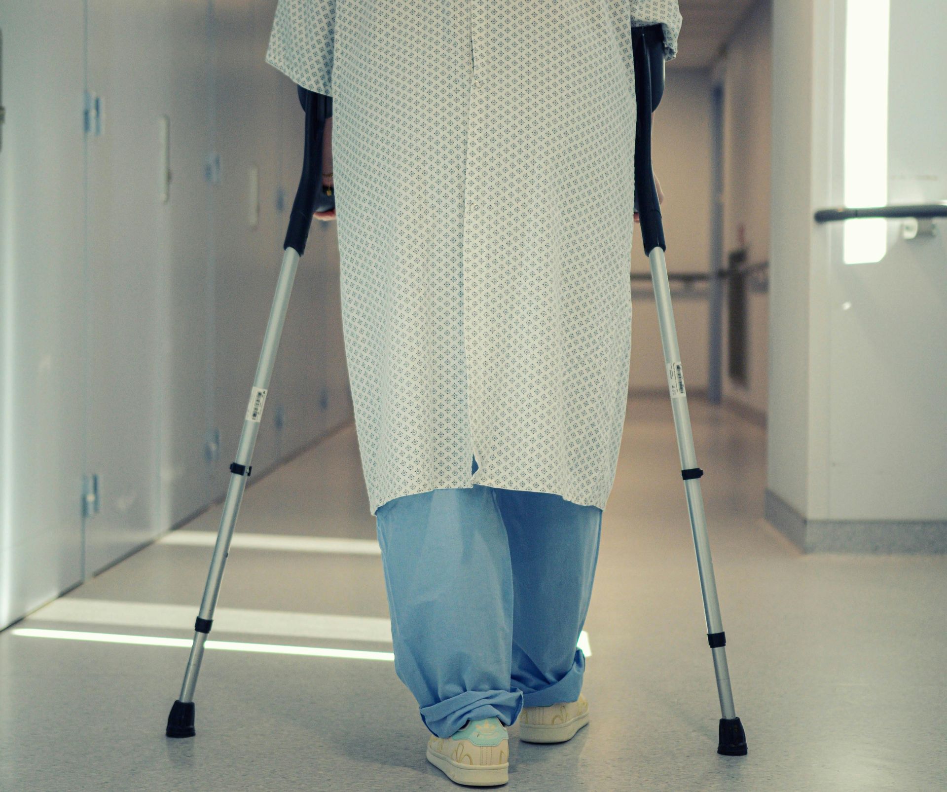 A person with crutches in a hospital hallway