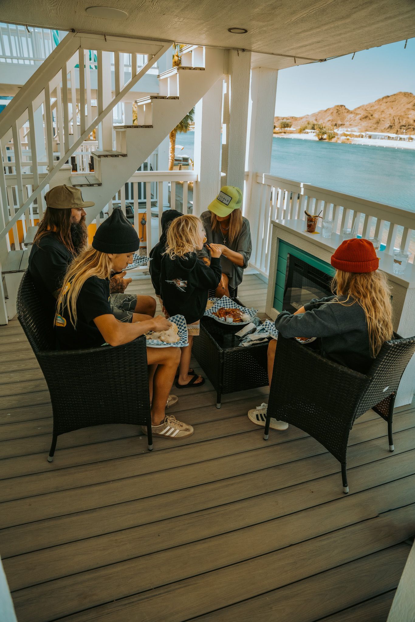 A group of people are sitting on a deck overlooking the ocean.