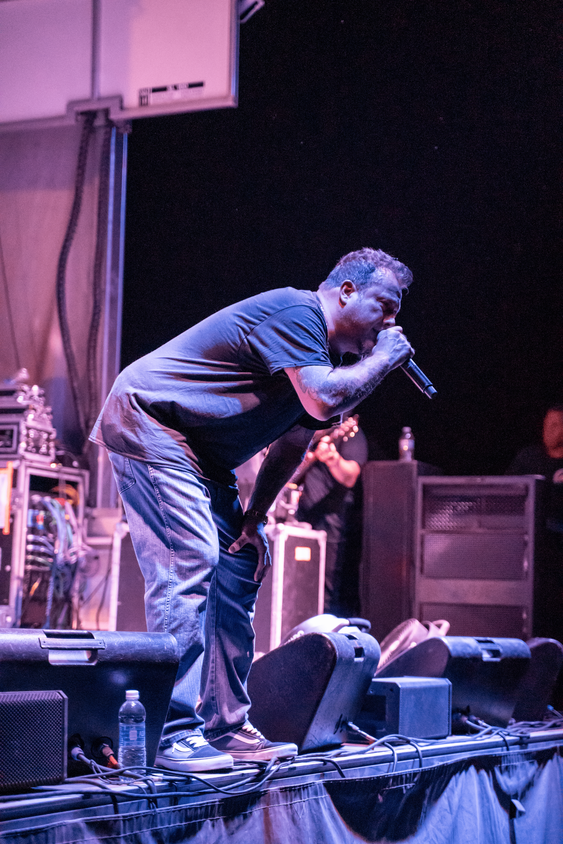 A man is singing into a microphone on a stage.