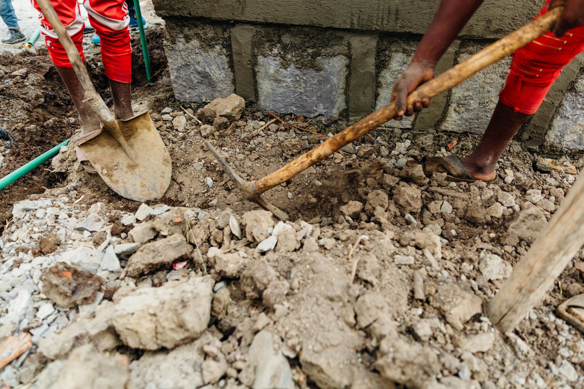 Two people are digging in the dirt with shovels.