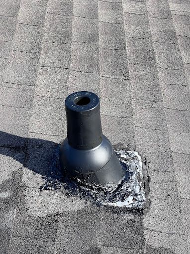 A black pipe is sitting on top of a roof.