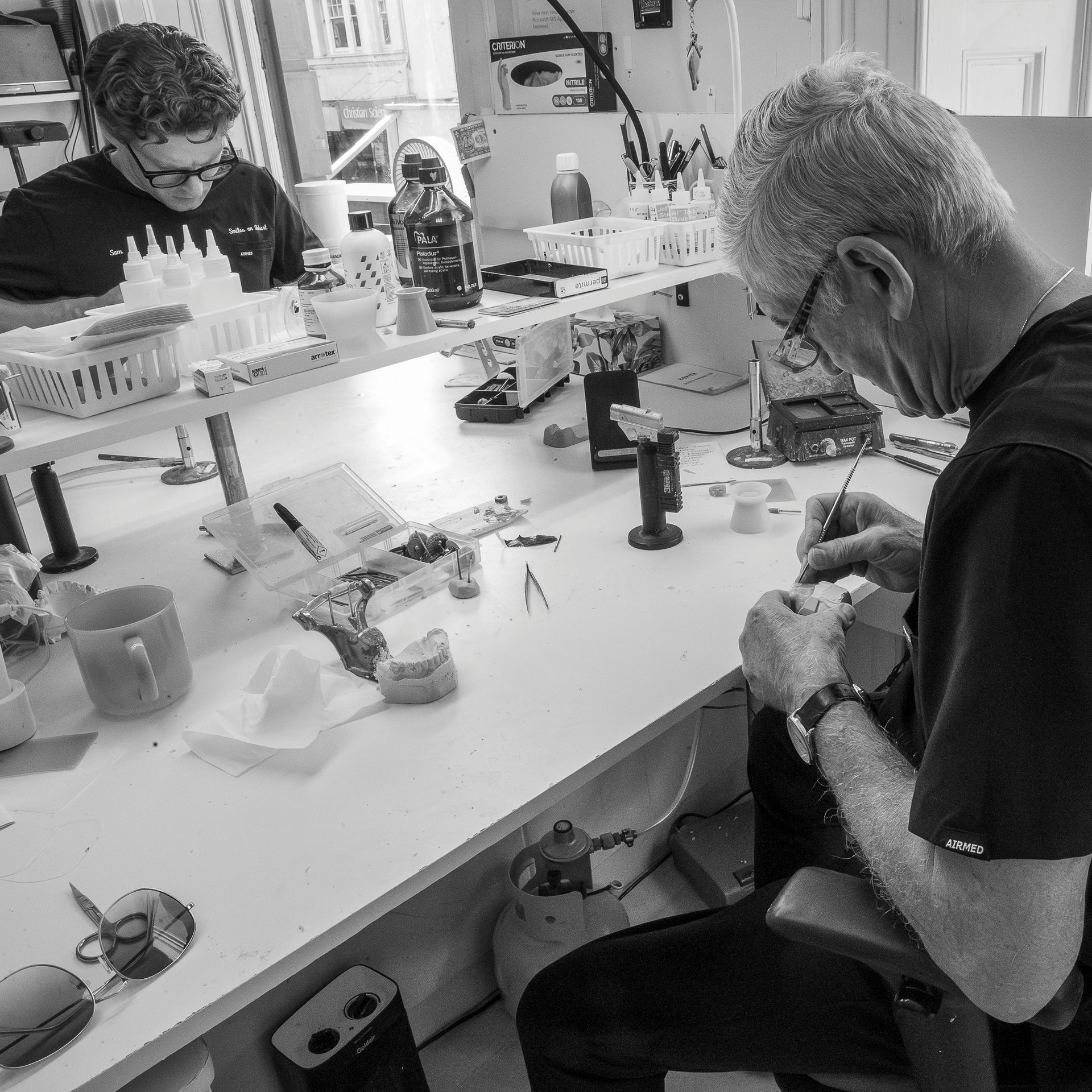 Two People Working at a Cluttered Lab Table — Smiles On Hobart in Hobart, TAS