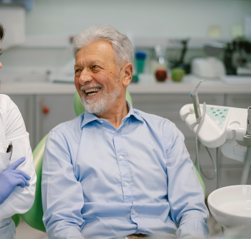 Smiling Man in a Light Blue Shirt Sitting in a Dental Clinic Chair — Smiles On Hobart in Hobart, TAS