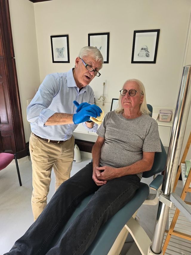Clinician Examining Seated Patient in a Bright Clinic Room — Smiles On Hobart in Hobart, TAS