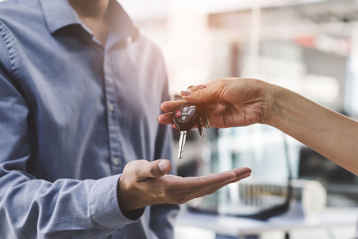 Person receiving car keys from another person's hand.  | Dave's Auto Care