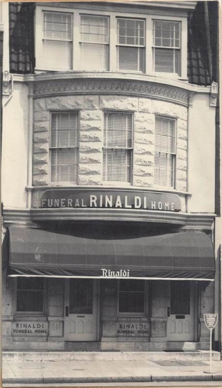 Black-and-white storefront with an awning and the sign “General Rinaldi Co.”