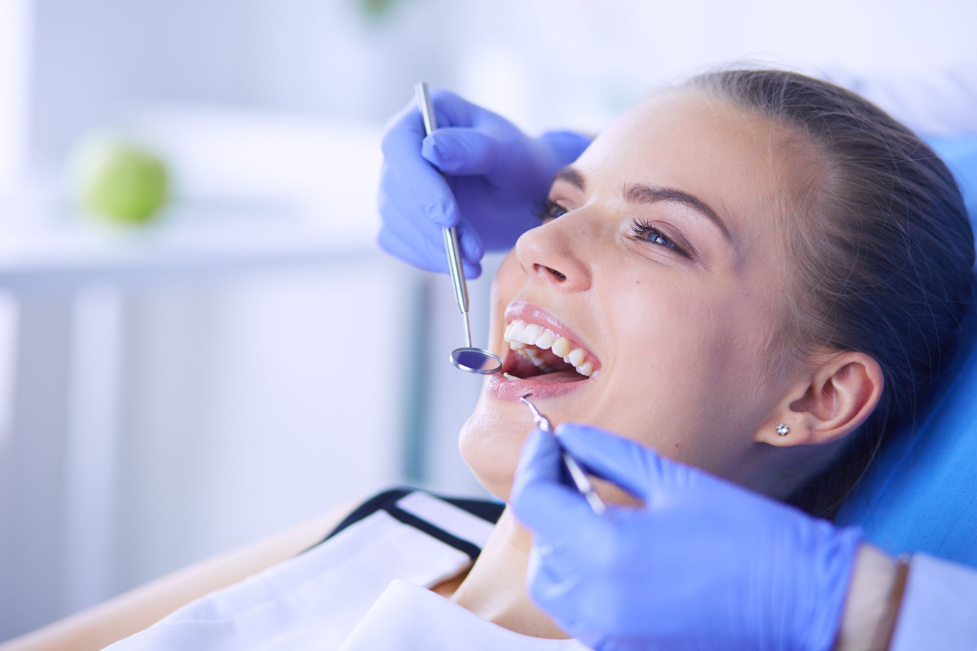 Dentist showing a patient their teeth in a mirror; they are both smiling in a dental office. Hope to see you soon text. Dentist showing a patient their teeth in a mirror; they are both smiling in a dental office. Hope to see you soon text.