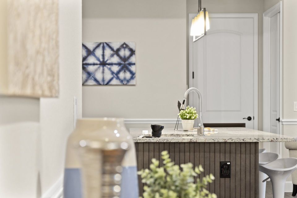 A kitchen with a sink and a vase on the counter.