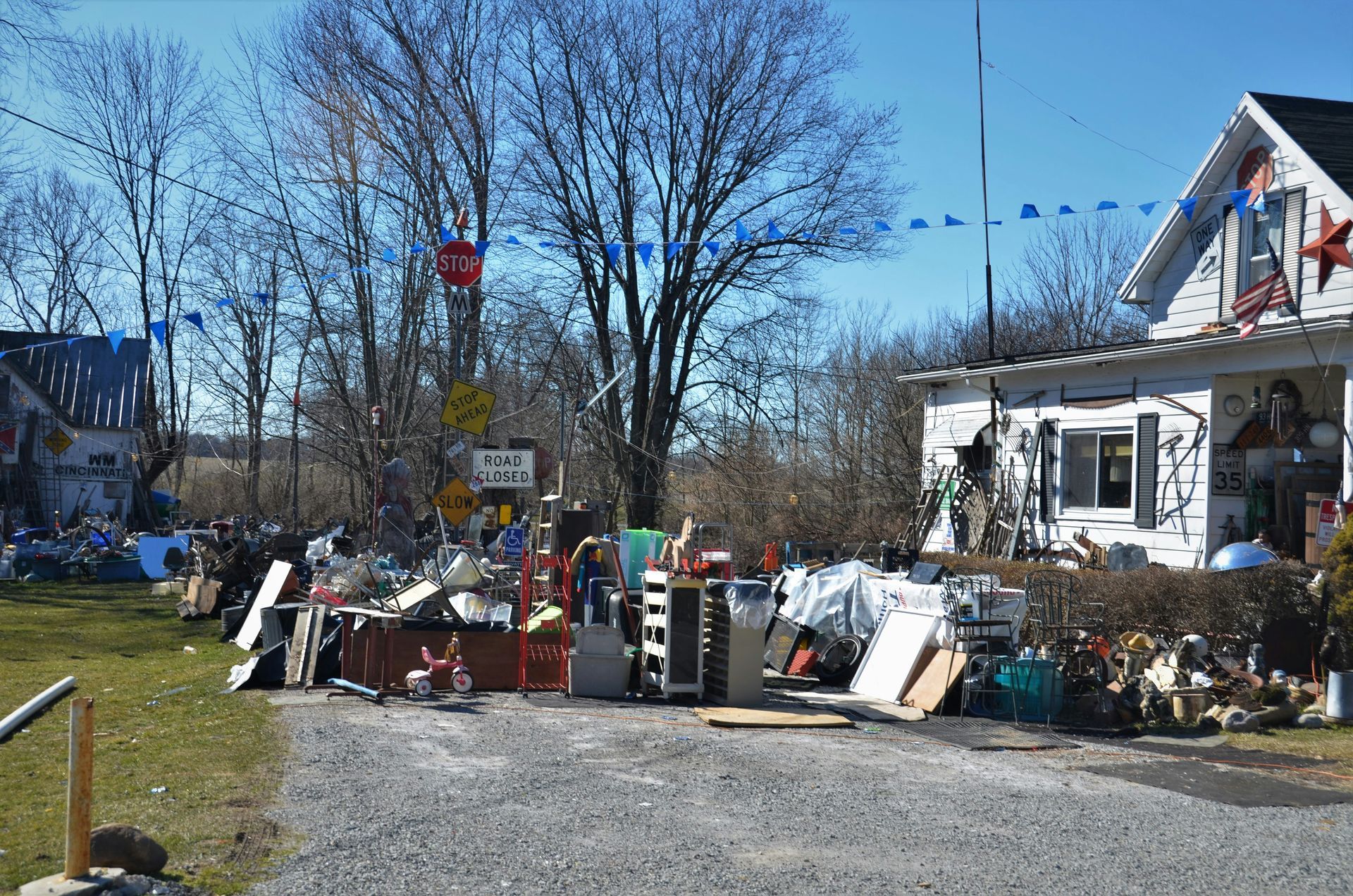 A house with lots of junk that is being removed and hauled away to clean up the property.