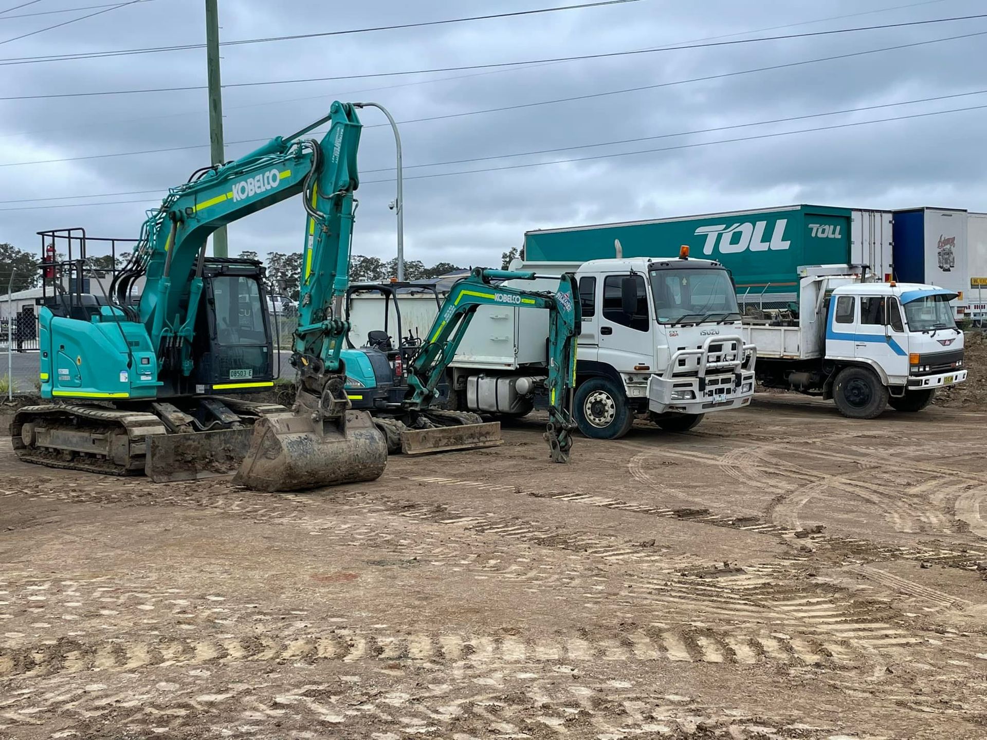 A Teal Excavator and Two White Trucks— All Stars Plumbing In Barrack Heights, NSW