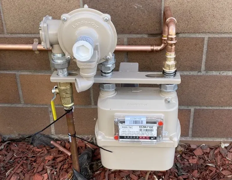 Gas Meter and Regulator Mounted on a Light-coloured Wall, With Copper and Steel Pipes — All Stars Plumbing In Kiama, NSW