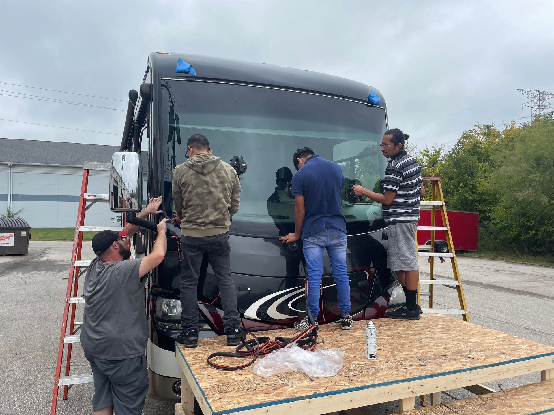 Four Men Installing Windshield On Bus — Indianapolis, IN — Rockstar Indy