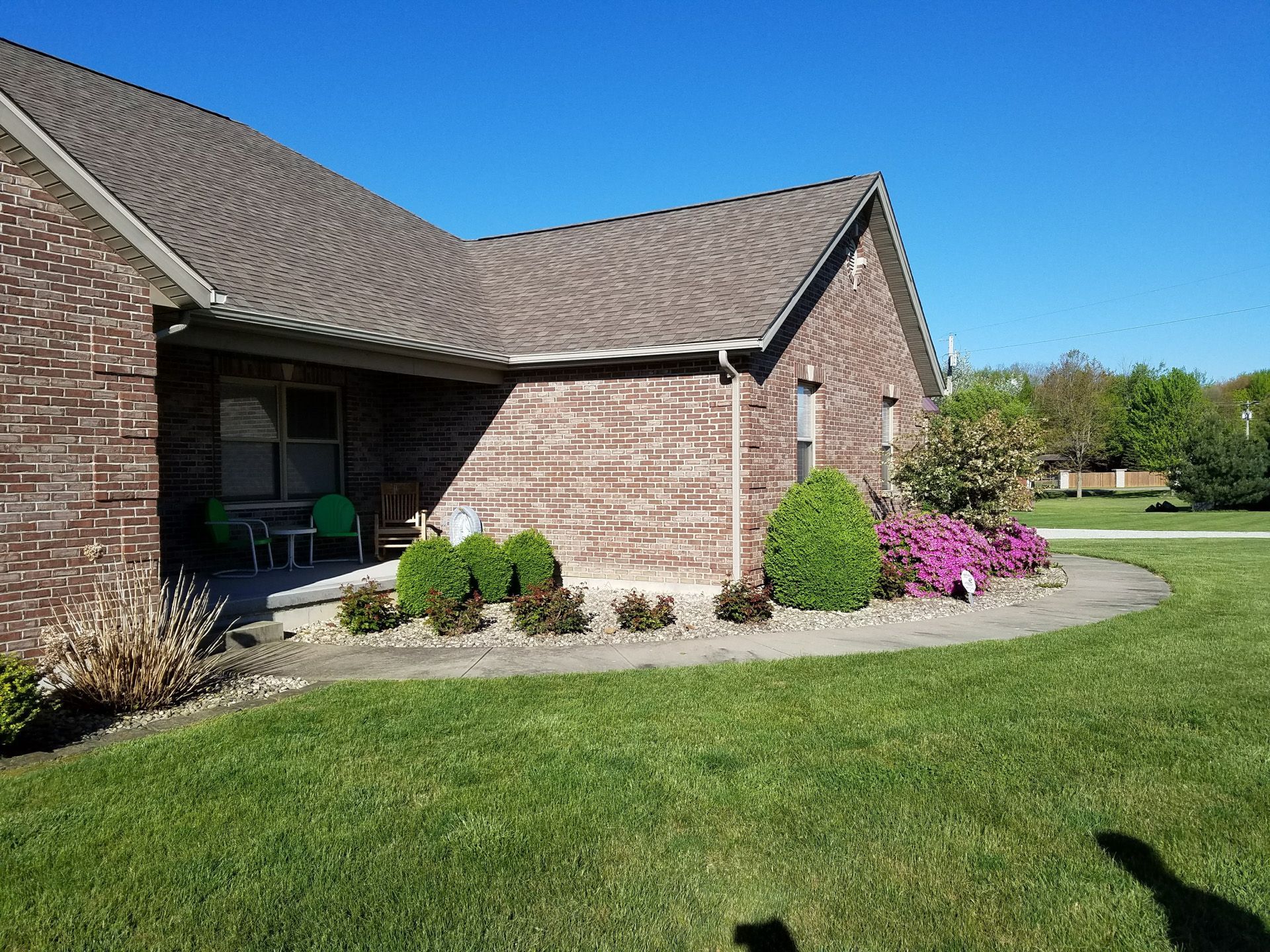 A brick house with a lush green lawn in front of it.