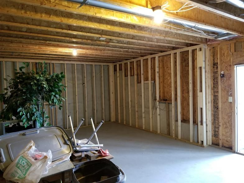 A room with a lot of wooden beams and a car in it.