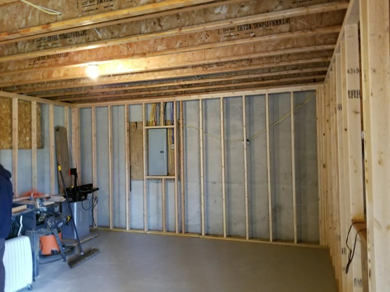 A man is standing in a room that is being built.