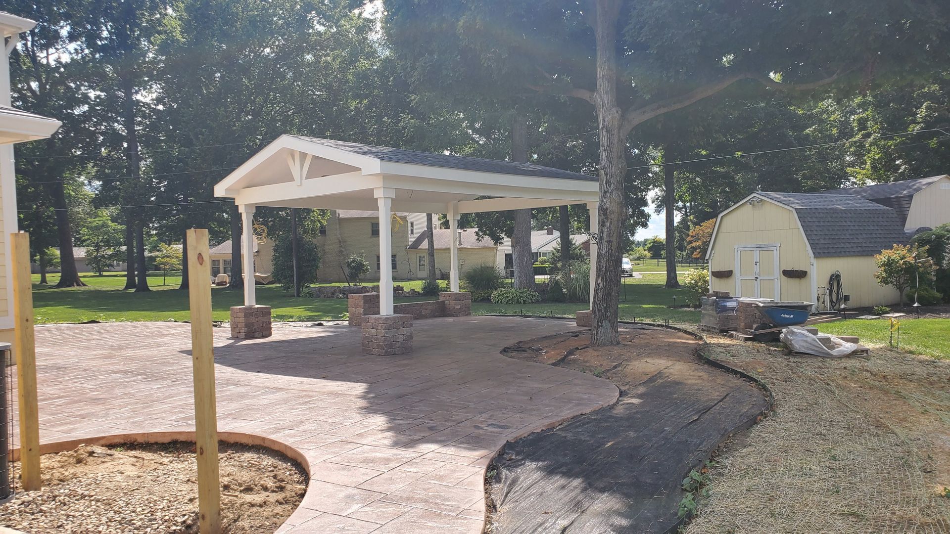 A carport is being built in the backyard of a house.