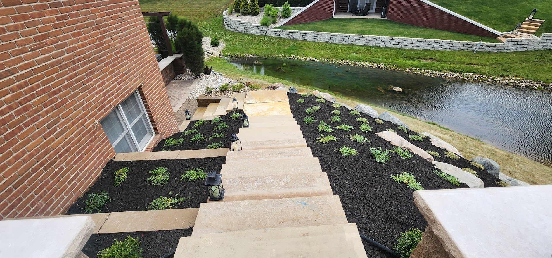 A set of stairs leading up to a house next to a pond.