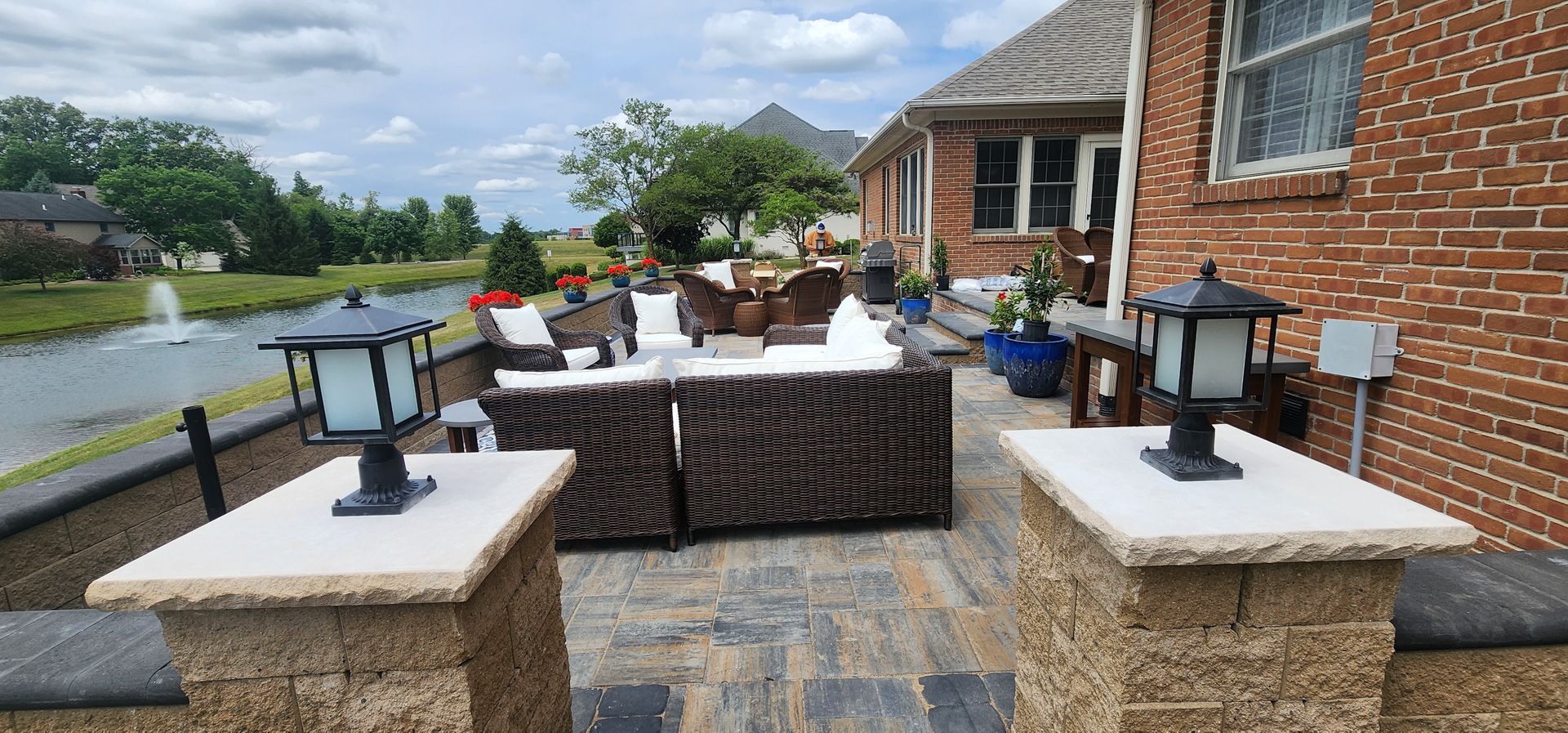 A patio with a lot of furniture and a fountain in the background.