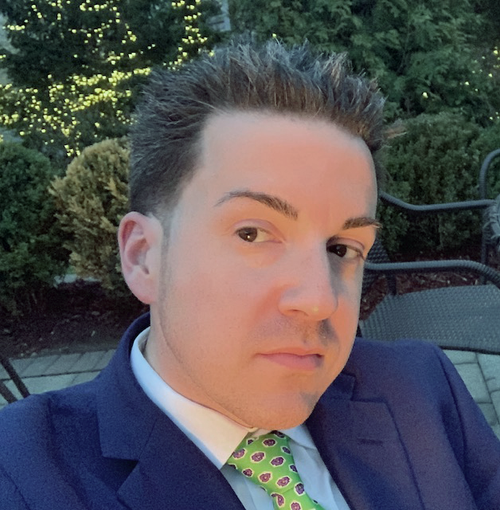 A man in a suit and tie is looking at the camera