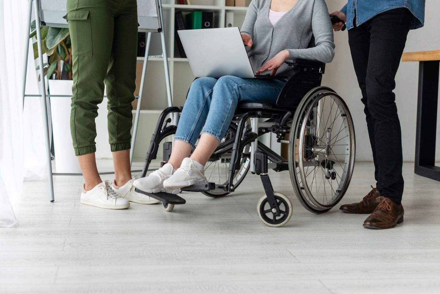 Medical professional assists a patient with a dumbbell exercise in a doctor's office.