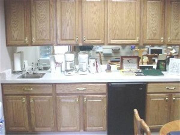 A kitchen with wooden cabinets and a black dishwasher