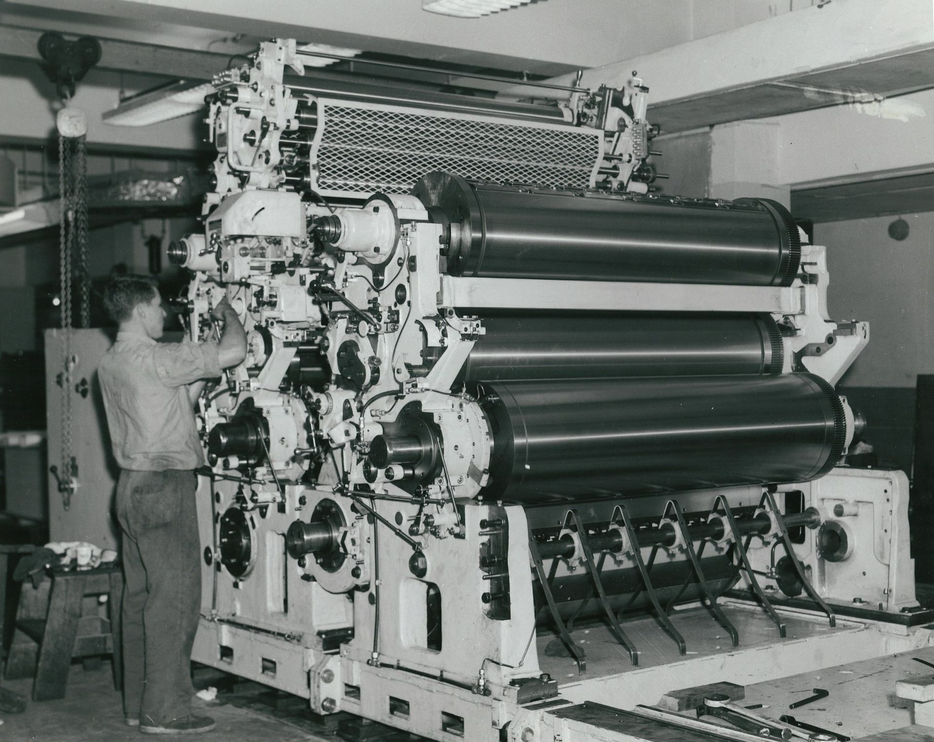 A black-and-white photo of a printing press operator at work