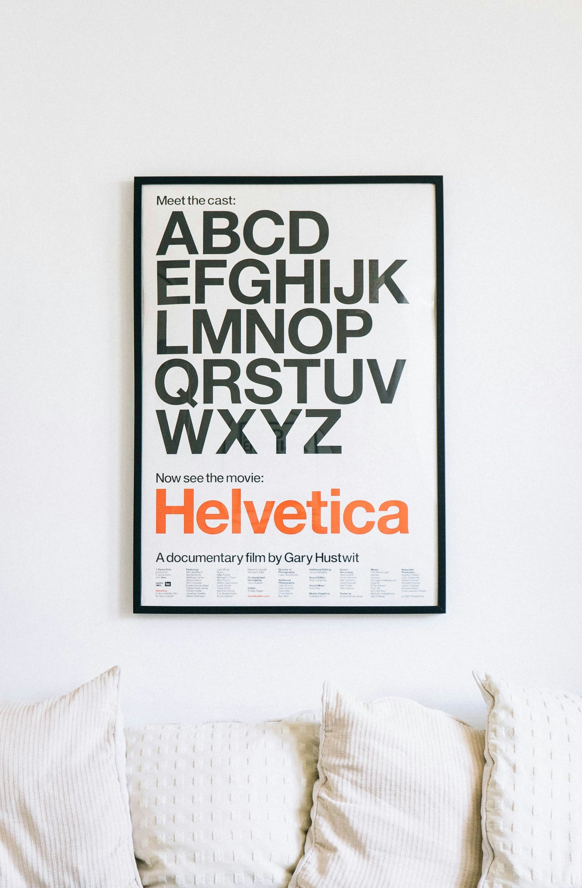 A framed Helvetica type specimen poster on a white wall