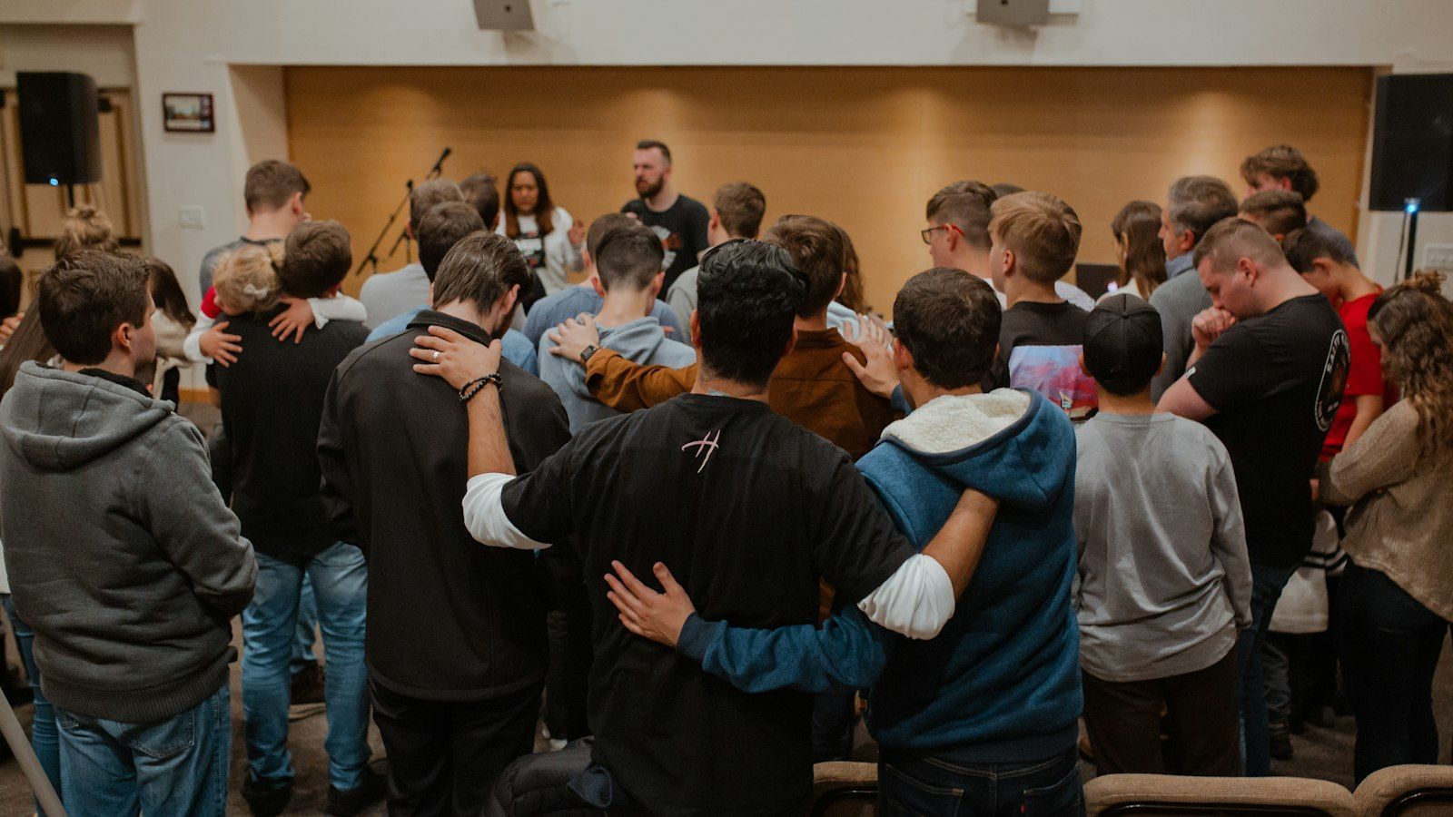 People with their arms around each other at a gathering