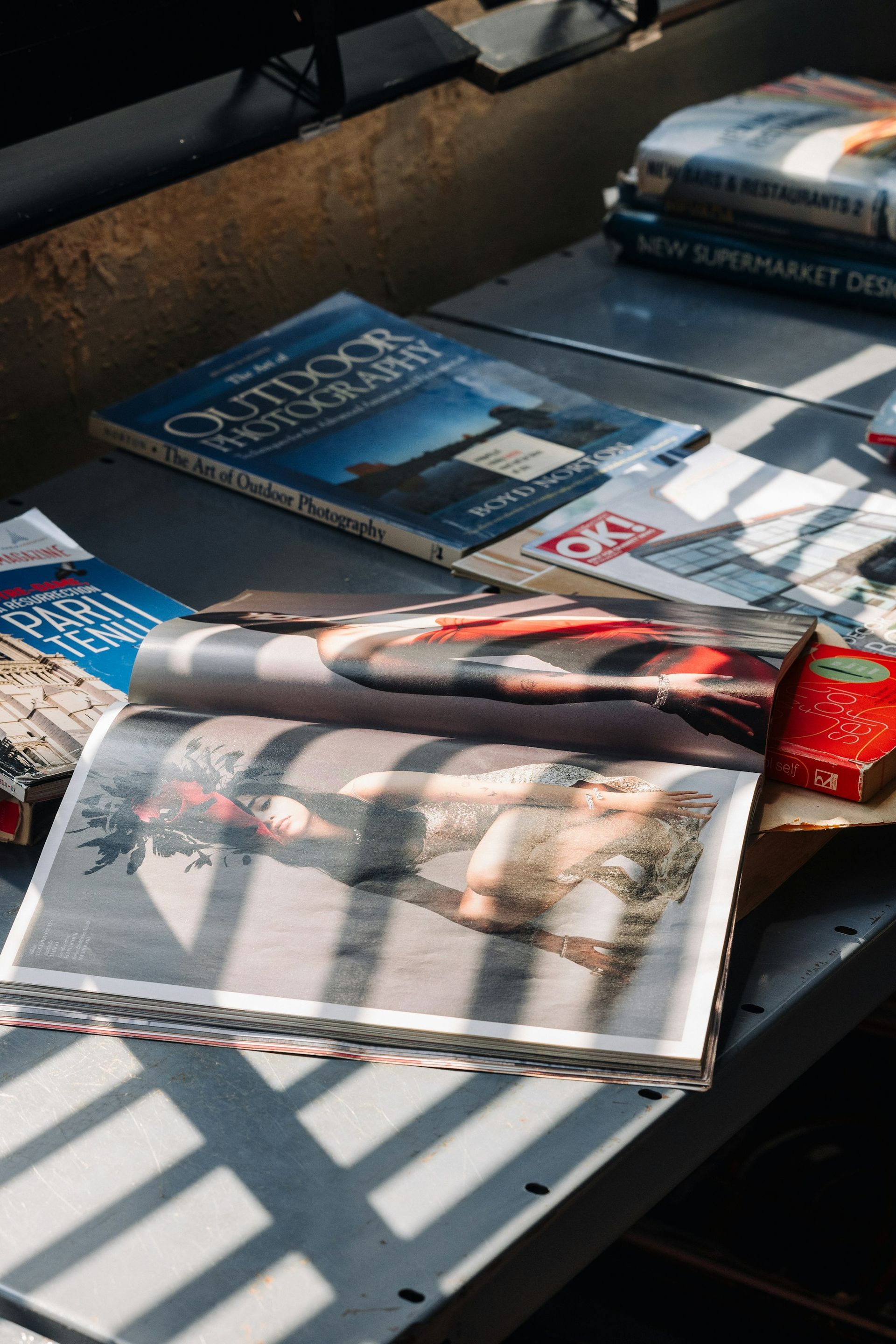 Magazines on a table in striped sunlight