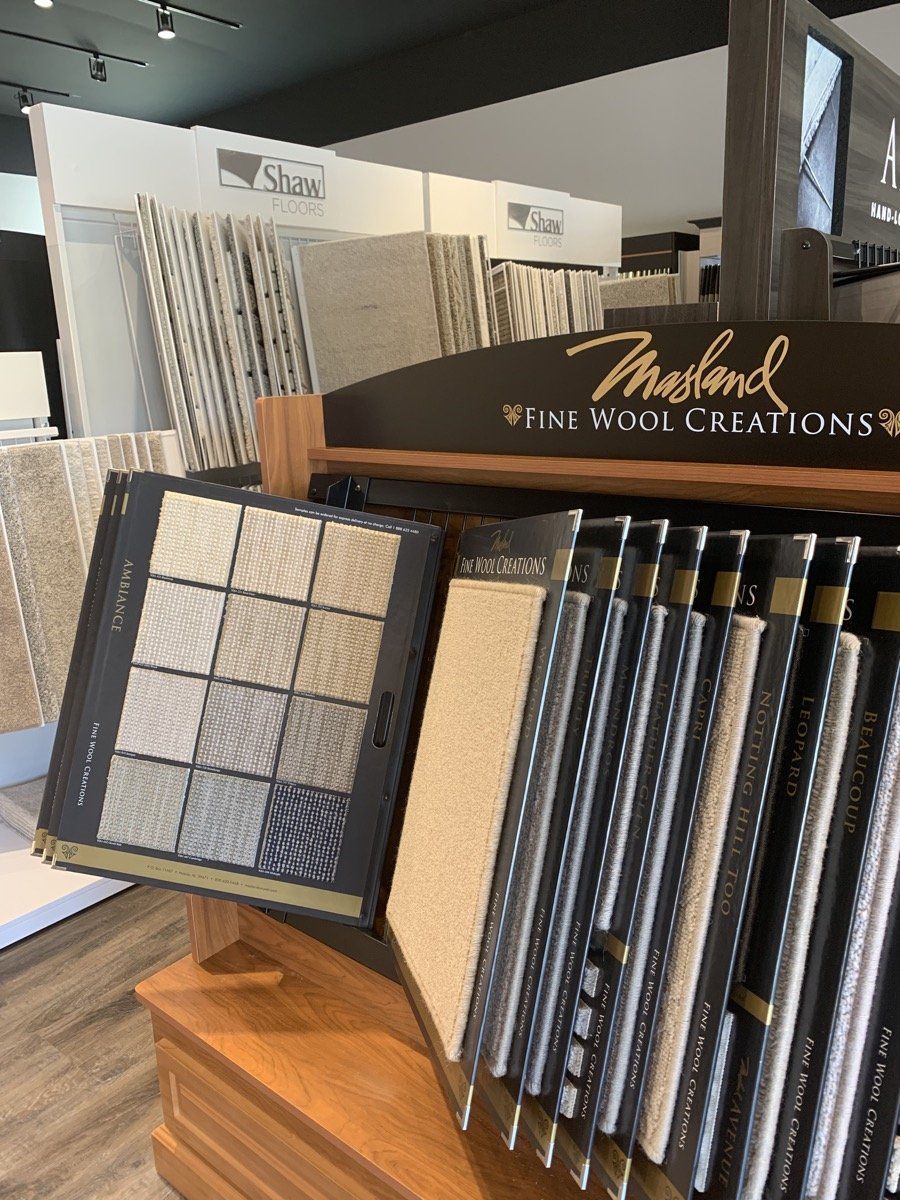 Flooring showroom display with carpet and tile samples on wooden stands