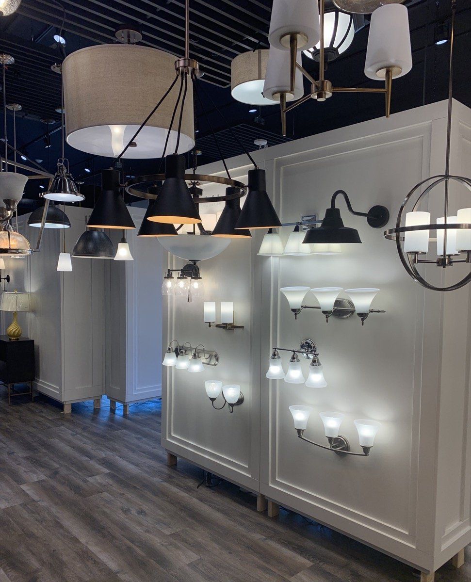 Lighting showroom with wall-mounted sconces and hanging pendant fixtures on display