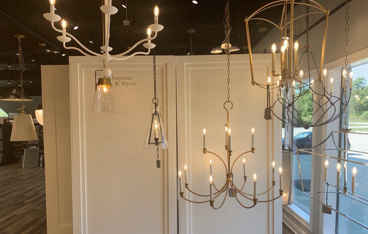 Assorted hanging pendant and chandelier lights displayed in a bright showroom