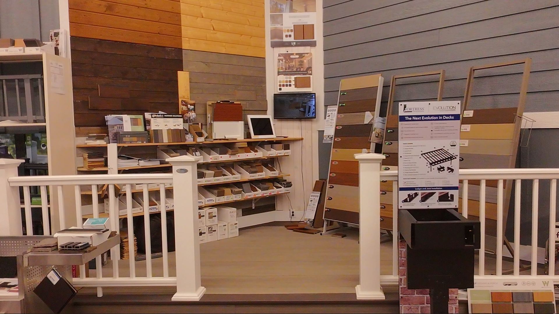 Indoor home showroom with white railings, wooden flooring, and shelves of decor and samples