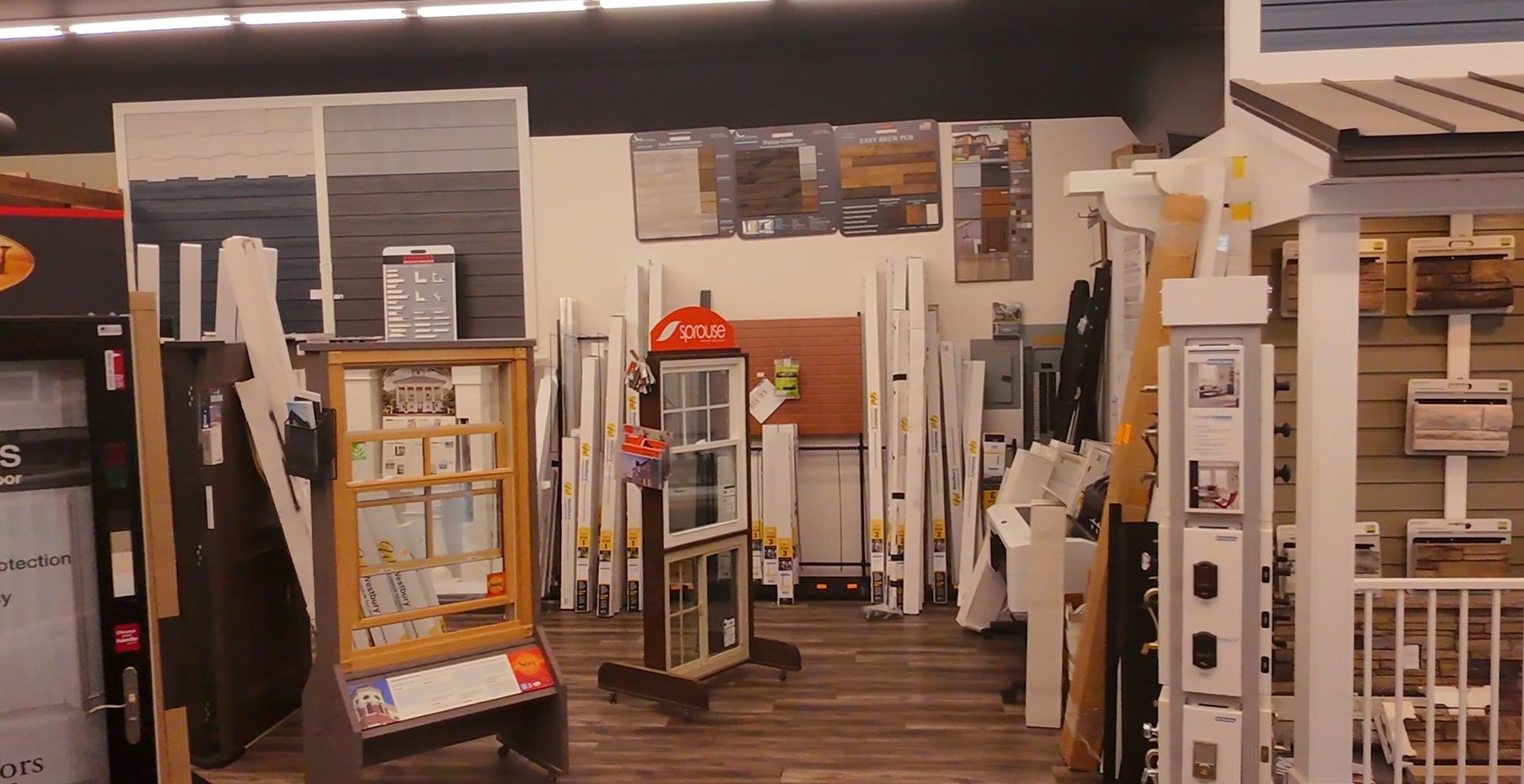 Hardware store aisle with display ladders, shelves, and home improvement supplies