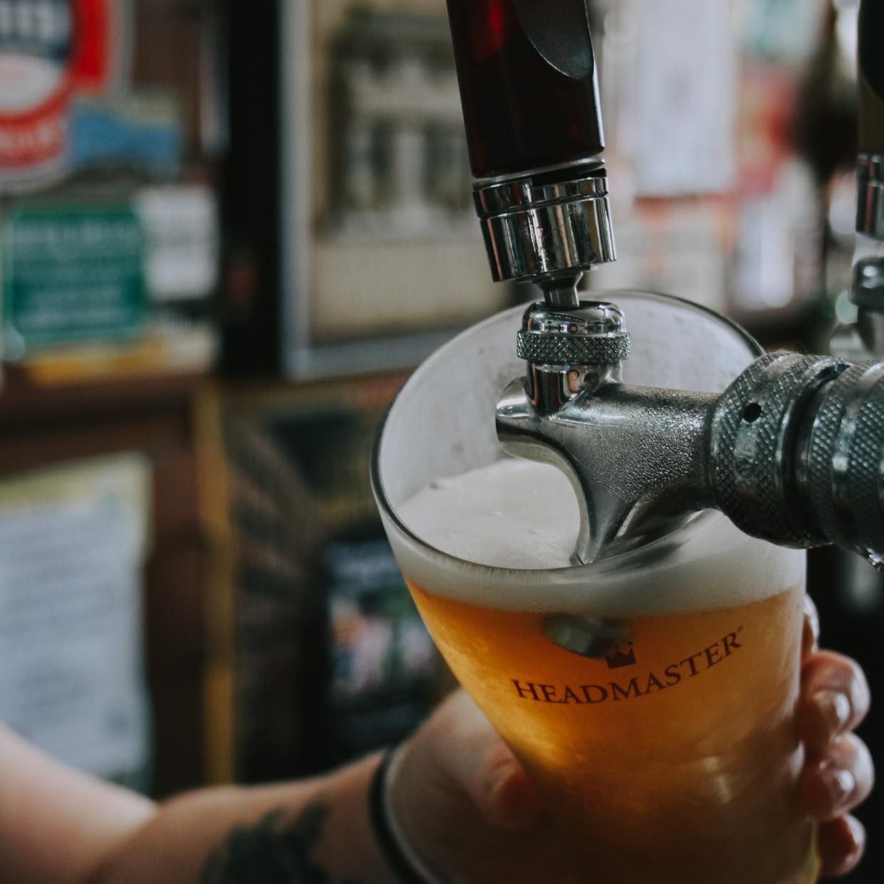 Beer being poured from a tap into a glass labeled
