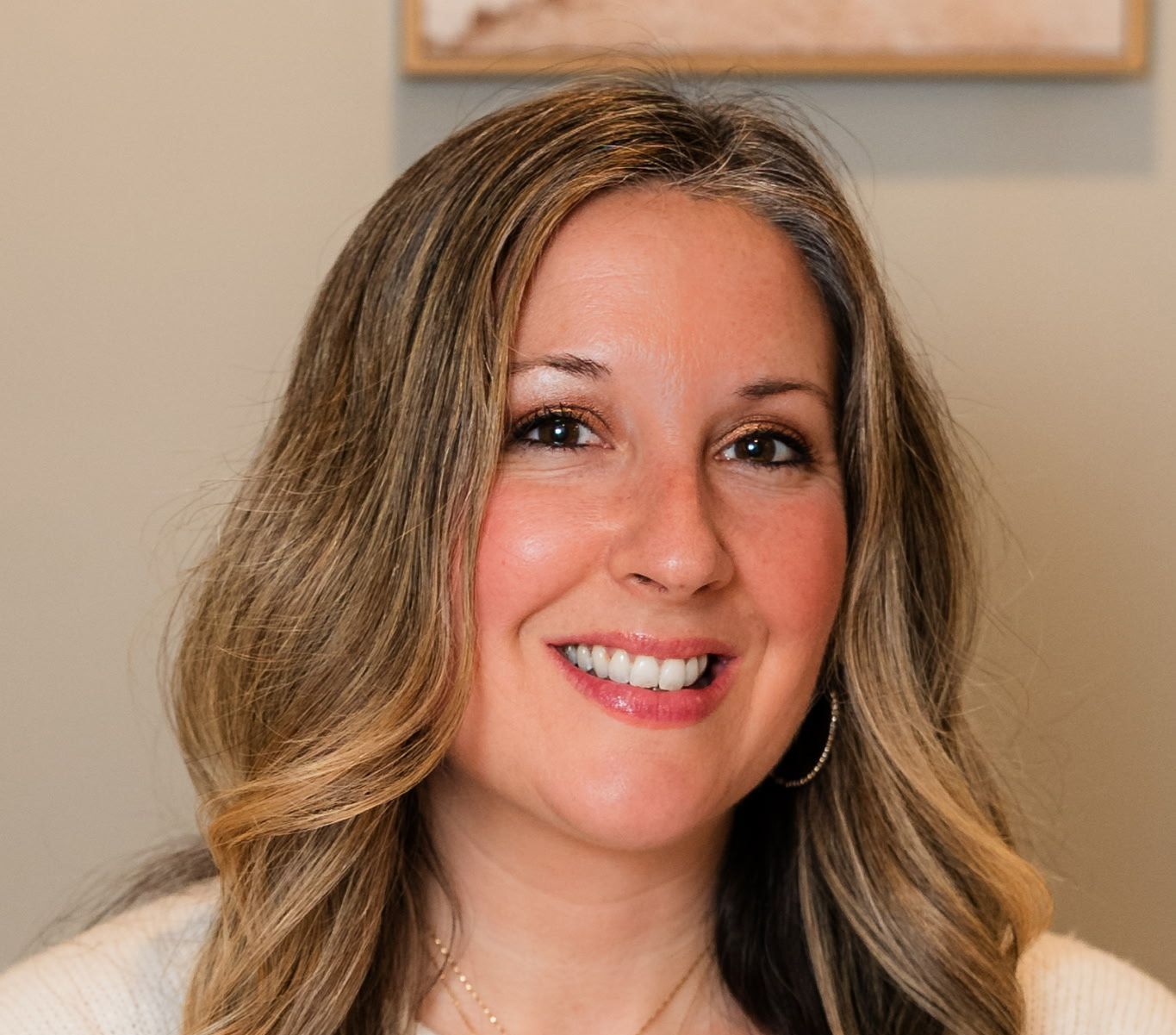 A woman with long hair is smiling for the camera.