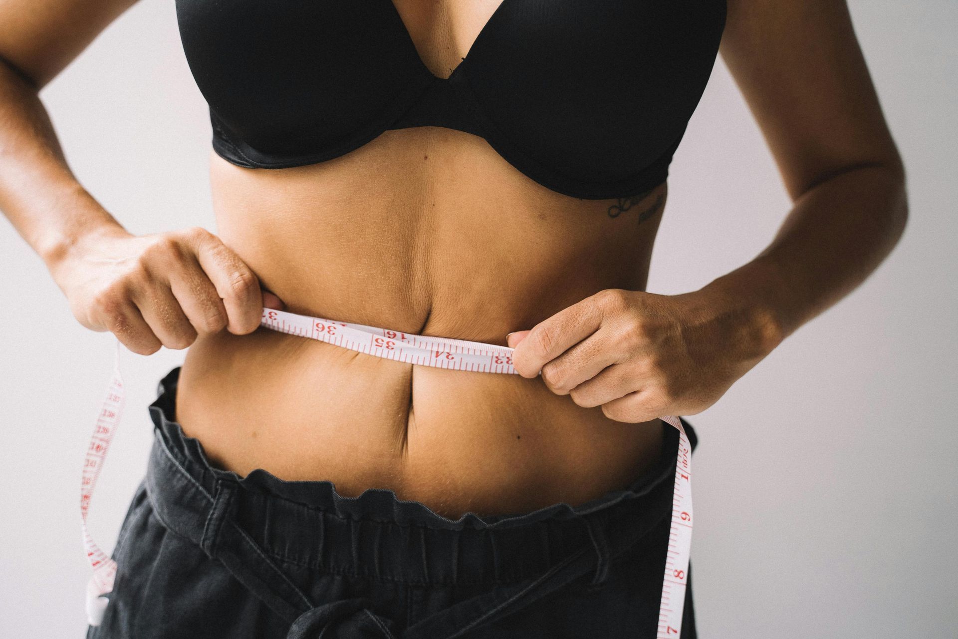 Mulher com fita métrica a medir a cintura