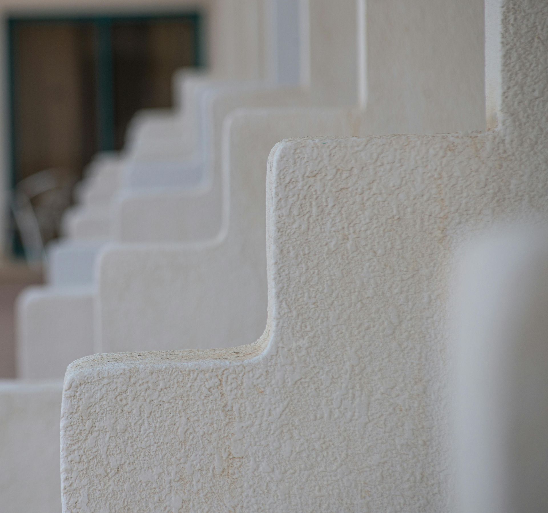 Row of white stucco stair railings in soft focus