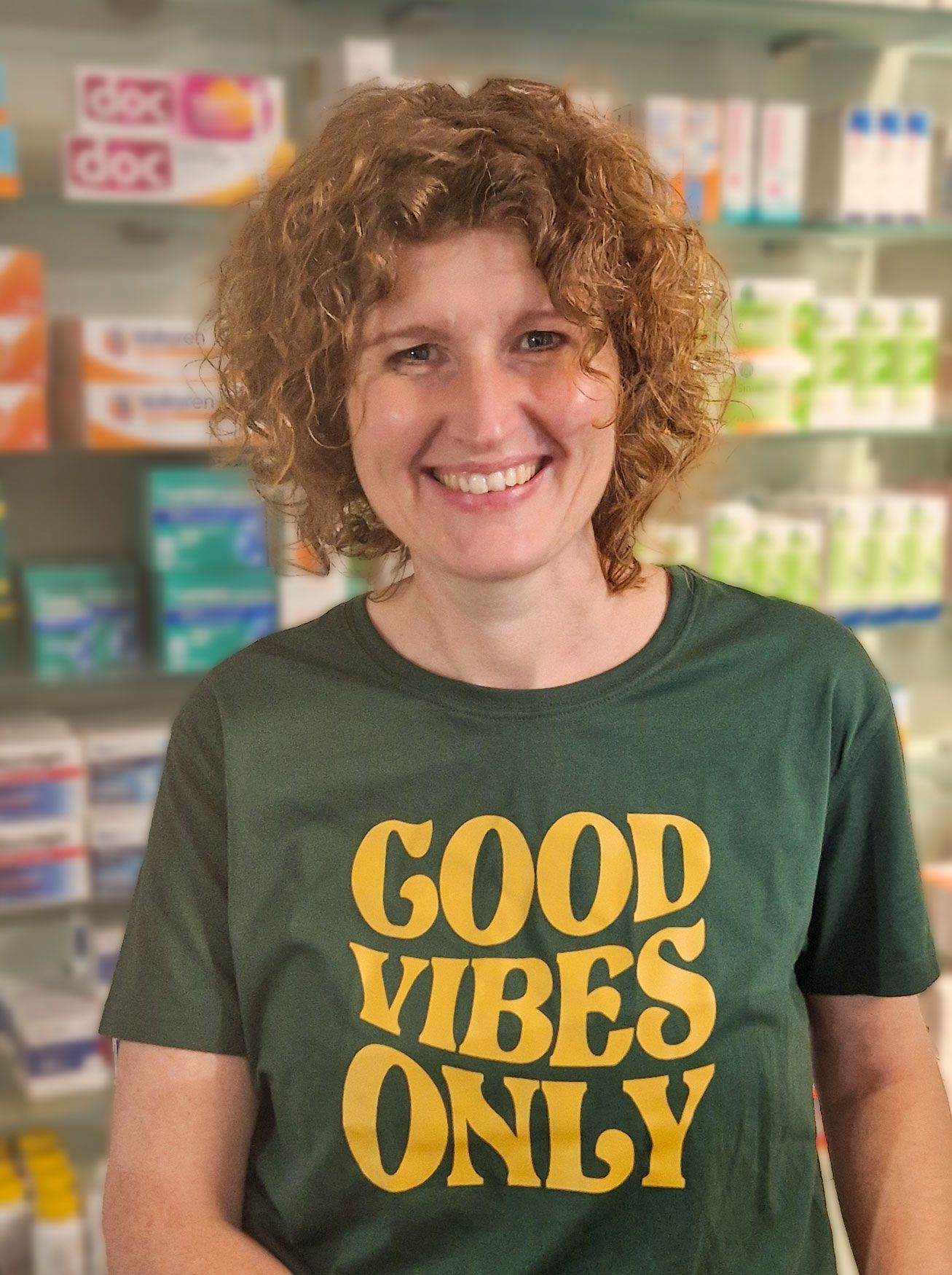 Eine Frau, die ein grünes T-Shirt mit der Aufschrift „Good Vibes Only“ trägt