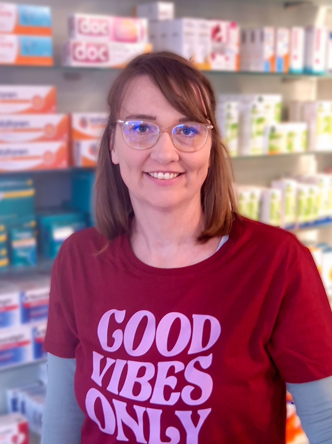 Eine Frau, die ein rotes T-Shirt mit der Aufschrift „Good Vibes Only“ trägt
