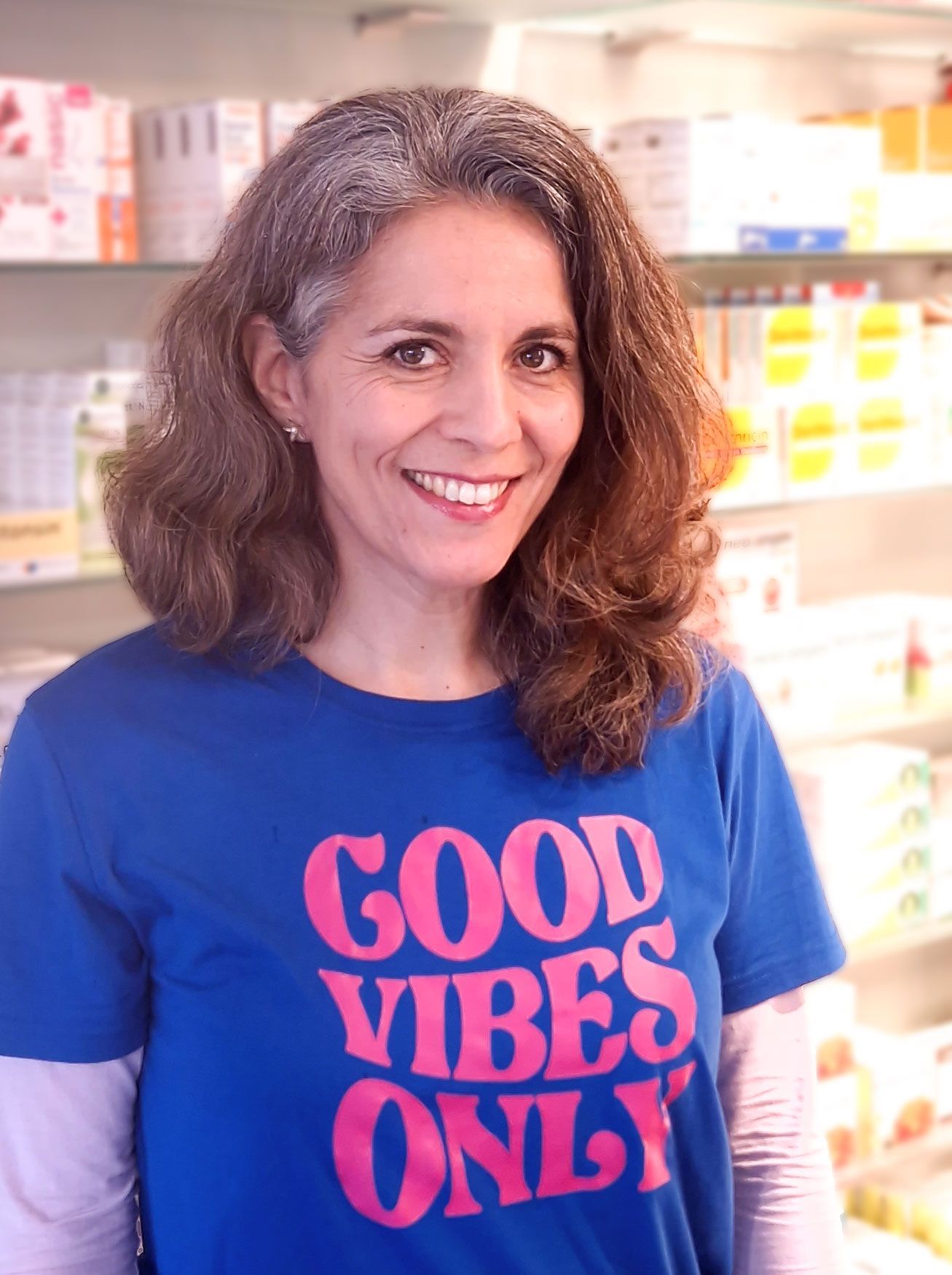 Eine Frau, die ein blaues T-Shirt mit der Aufschrift „Good Vibes Only“ trägt