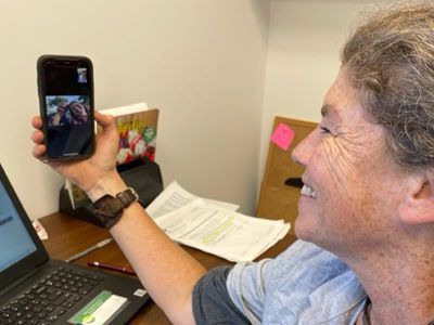 A woman is taking a picture of herself on her cell phone.